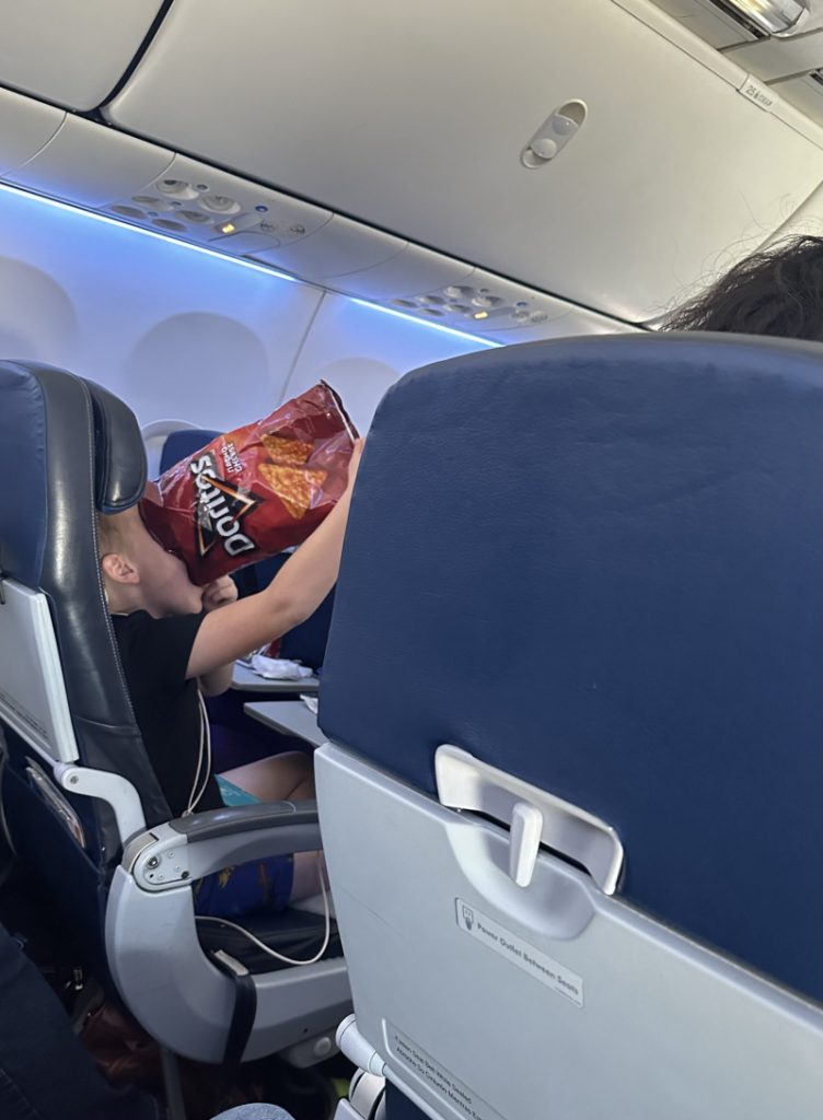 plane ride family size bag of Doritos and drinking soda